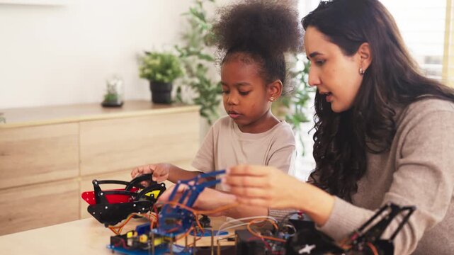 Mother and daughter assemble a diy robotics kit at home, building curiosity and problem solving through stem education, with teamwork and hands-on stem education guiding each step.