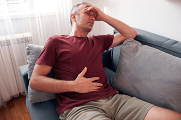 Man with gastritis, chest and abdominal pain at home.