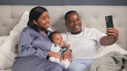 Happy Family Taking a Selfie Together on a Comfortable Bed in Their Home