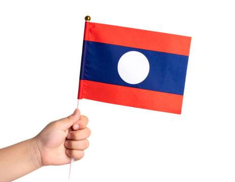 A hand holds the national flag of Laos, featuring horizontal stripes of red and blue with a white circle.