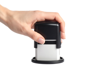 A hand holds a self-inking stamp, ready to mark a document.