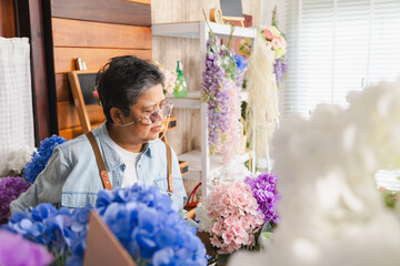 Asian senior woman, florist, small business owner proudly holds open sign with smile, ready to...