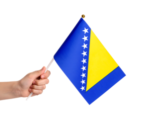 A hand holding the national flag of Bosnia and Herzegovina.
