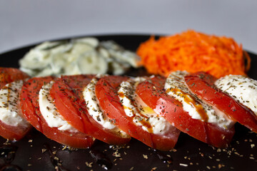 Vegetarian dish with a delicious Italian caprese salad, with olive oil and balsamic vinegar; with grated carrot salad and cucumber salad with cream vinaigrette.