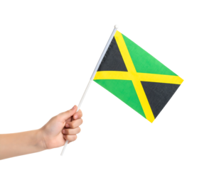 A hand is holding the national flag of Jamaica, with its distinctive black, green, and gold saltire.