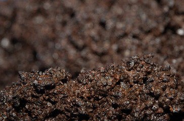 Close up of wet coffee grinds that looks like soil or mud background