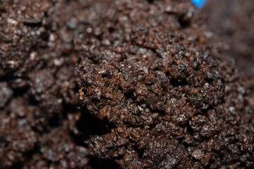 Close up of wet coffee grinds that looks like soil or mud background