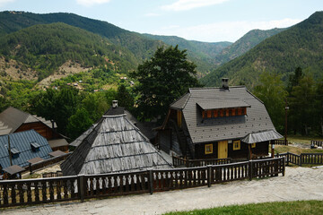 Scenic view of wooden houses in Drvengrad village surrounded by lush green hills, Mokra Gora,...