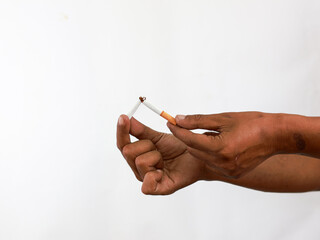 Close up of person breaking cigarette in half isolated on white background. stop smoking concept.
