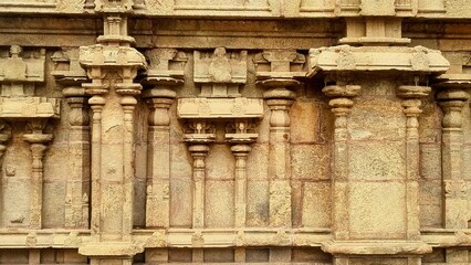 Intricately carved stone wall of a South Indian temple showcasing traditional Dravidian architecture with mythical Yali sculptures and ornate columns, located at Azhagar Temple, Madurai, Tamil Nadu