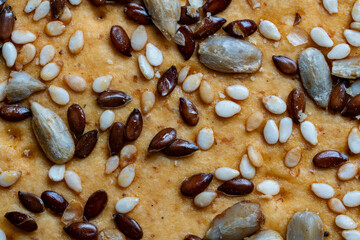 Background and texture of whole grain cookies made from flax, sesame and sunflower seeds, closeup, top view. Homemade healthy trendy cereal cookies with various seeds