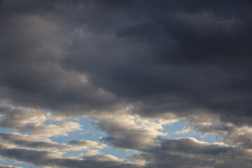 Dramatic timelapse of dark storm clouds rolling across a turbulent blue sky at sunset