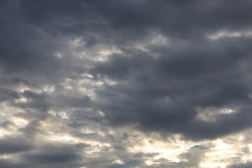 Dramatic timelapse of dark storm clouds rolling across a turbulent blue sky at sunset