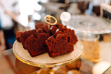 Fresh and flavorful desserts are tempting under the glass dome of this cozy bakery. Cozy atmosphere with fragrant cinnamon buns, cupcakes and muffins in the coffee shop. Dessert and food concept.