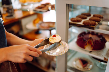 Fresh and flavorful desserts are tempting under the glass dome of this cozy bakery. Cozy atmosphere with fragrant cinnamon buns, cupcakes and muffins in the coffee shop. Dessert and food concept.