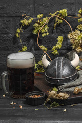 Creative Oktoberfest composition. Dark beer, viking helmet, hop and wheat. German festival concept