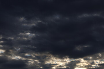 Dramatic timelapse of dark storm clouds rolling across a turbulent blue sky at sunset