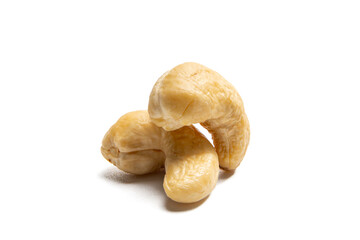 Three cashew nuts isolated on a white background. Three blanched cashew nuts lie stacked on a white background. The typical C-shape of the nuts is clearly visible.