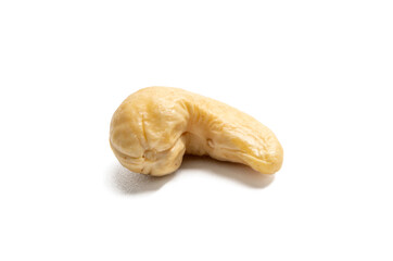 Single cashew nut isolated on a white background. A single, blanched cashew nut lies isolated on a white background. The natural, curved shape is clearly visible.