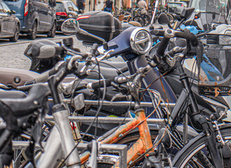 parked bicycles and scooters on a city street
