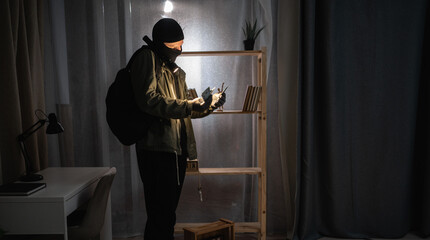 Searching Money. thief making burglary stealing from house