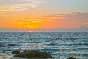 Sunset over Kata Beach with rocky shore Phuket