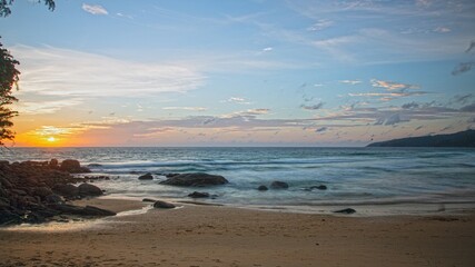 Sunset over Kata Beach with rocky shore Phuket