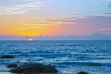 Sunset over Kata Beach with rocky shore Phuket