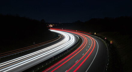 Obraz premium Night highway with light trails showing traffic movement and speed in a long exposure shot