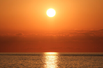 Beautiful sunset over the sea. The sun goes down over the sea. Sunset over the sea with orange sky and sun in the background