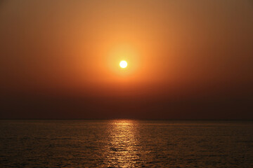Beautiful sunset over the sea. The sun goes down over the sea. Sunset over the sea with orange sky and sun in the background