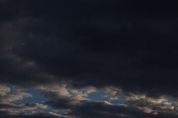 Dramatic timelapse of dark storm clouds rolling across a turbulent blue sky at sunset
