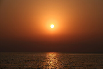 Obraz premium Beautiful sunset over the sea. The sun goes down over the sea. Sunset over the sea with orange sky and sun in the background
