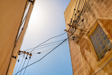 Low-angle view of electric cables with ceramic insulators, plastic clamps, wire joints, and...