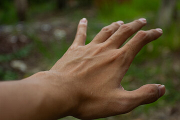 Close-up of a man's hand reaching or grabbing. Concept of help, desire, and effort.
