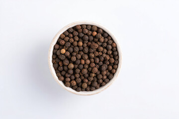 Fototapeta premium a bowl of black pepper seeds on a white surface