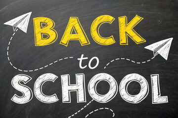 Back to school message written in chalk on a blackboard with paper airplanes flying