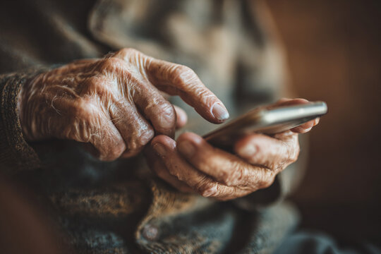 Close-Up of Elderly Person’s Hand Using Smartphone Highlighting Technology Use in Seniors


