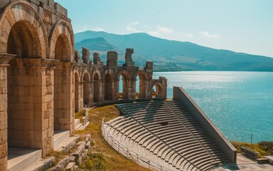 Ancient Roman Amphitheater Overlooking a Sparkling Mediterranean Sea Under a Clear Blue Sky