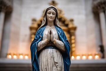 Virgin Mary statue in blue robe with candles, Mary statue at ornate church altar, Faith and devotion religious concept image