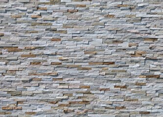 External wall coating made of  stone bricks of different colors. Full frame. Background and texture.