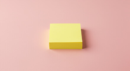 Vibrant yellow sticky note pad rests on a soft pink surface, perfect for capturing ideas and organizing tasks with a touch of modern simplicity