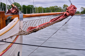 Curved Bow With Bowsprit Net And Jib Sails On White Wooden Sailboat Lauterbach