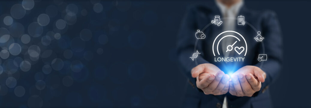 Longevity and wellness, longevity economy. Holds a glowing digital interface featuring icons related to longevity, health and wellness. Longer, healthier life through lifestyle and medical choices.