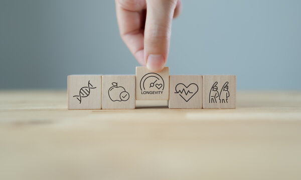 Health and longevity, longevity economy concept. Wooden blocks with icons related to health, genetics, aging and longevity. A holistic approach to a healthy lifestyle and extended life expectancy.