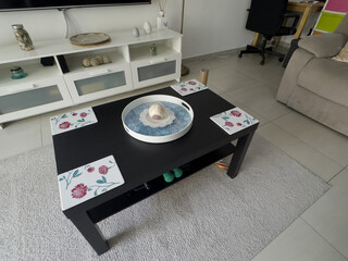 A modern living room with a neutral color scheme, comfortable seating, a coffee table, a rug, and a...