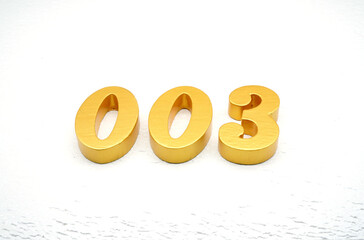 The numbers are made of gold-painted wood, placed on a white background.