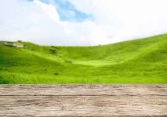 Wooden table top on blur mountain and grass field.Fresh and Relax concept.For montage product display or design key visual layout.View of copy space.