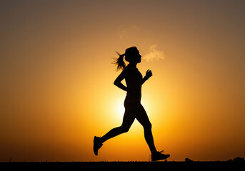 Silhouette of Woman Running at Sunrise Exhaling Breath in Cold Air for Fitness, Wellness, and Healthy Lifestyle Concepts