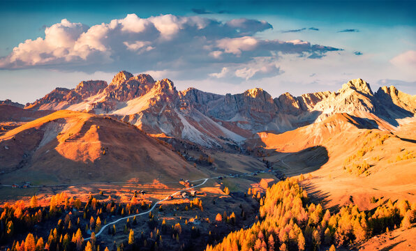 Fototapeta Breathtaking autumn scene of Fuchiade valley. Impressive evening view of Dolomite Alps, Italy, Europe. View from flying drone of golden larch trees forest at the foot of huge peaks.